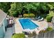 Aerial view of the backyard featuring a pool, surrounding patio, deck and lush landscaping at 7508 Venture Ct, Raleigh, NC 27615