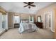 Spacious primary bedroom featuring a tray ceiling, carpeted floors, and large windows at 7508 Venture Ct, Raleigh, NC 27615