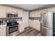 Well-lit kitchen featuring stainless steel appliances, white cabinetry, and stylish tile backsplash at 7508 Venture Ct, Raleigh, NC 27615