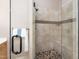 Walk-in shower featuring tile walls, pebble floor, and a built-in seat at 7508 Venture Ct, Raleigh, NC 27615