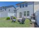 Backyard with a cozy seating area, manicured lawn, and a partial view of the surrounding neighborhood at 79 Hawkstone Dr, Clayton, NC 27527
