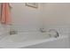 Corner soaking tub in bathroom featuring white subway tile surround and modern fixtures at 79 Hawkstone Dr, Clayton, NC 27527