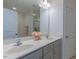 Bright bathroom featuring a double vanity with gray cabinets, white countertops, and a large mirror at 79 Hawkstone Dr, Clayton, NC 27527