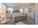 Bright bedroom with a large decorative bed frame, soft carpet, and natural light filtering through the sheer curtains at 79 Hawkstone Dr, Clayton, NC 27527