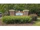 Woodlands at Flowers Plantation entrance sign with brick pillars and lush landscaping at 79 Hawkstone Dr, Clayton, NC 27527