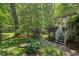 The back of a house has a screened in porch with stone steps and is surrounded by trees at 800 Oxbow Crossing Rd, Chapel Hill, NC 27516