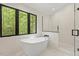 Serene bathroom showcasing a soaking tub, walk-in shower, and large window with nature view at 800 Oxbow Crossing Rd, Chapel Hill, NC 27516