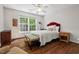 Bright bedroom featuring a hardwood floor, red headboard, and a large window offering ample natural light at 800 Oxbow Crossing Rd, Chapel Hill, NC 27516