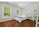 Cozy bedroom featuring hardwood floors, a large window, neutral walls, and simple elegant furniture at 800 Oxbow Crossing Rd, Chapel Hill, NC 27516