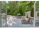 Outdoor deck with lounge chairs, dining table, and serene wooded views at 800 Oxbow Crossing Rd, Chapel Hill, NC 27516