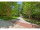 Long paved driveway lined with trees leading to the home, showcasing the property's curb appeal at 800 Oxbow Crossing Rd, Chapel Hill, NC 27516