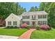 Charming two-story home with a manicured lawn, mature trees and inviting red brick walkway at 800 Oxbow Crossing Rd, Chapel Hill, NC 27516