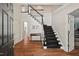 Elegant foyer with hardwood floors, staircase with black and white accents, and ample lighting at 800 Oxbow Crossing Rd, Chapel Hill, NC 27516
