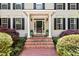Inviting front porch with brick steps, white columns, and manicured landscaping at 800 Oxbow Crossing Rd, Chapel Hill, NC 27516