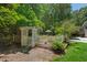 White arbor entryway leads to a beautiful garden oasis with lush greenery and an umbrella-covered seating area at 800 Oxbow Crossing Rd, Chapel Hill, NC 27516
