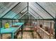 Bright greenhouse interior with sink, shelving, and ample space for gardening projects at 800 Oxbow Crossing Rd, Chapel Hill, NC 27516