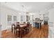 Open floor plan connecting the kitchen, dining area, and featuring hardwood floors and white cabinetry at 800 Oxbow Crossing Rd, Chapel Hill, NC 27516