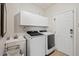 Functional laundry room with a sink, washer and dryer, storage cabinets, and an access door at 800 Oxbow Crossing Rd, Chapel Hill, NC 27516