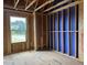 Unfinished bedroom showing framing and construction stage, with view of a large window at 803 Fireship Rd, Fuquay Varina, NC 27526