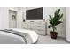 Modern bedroom with a large TV, stylish dresser, and a cozy bed at 803 Fireship Rd, Fuquay Varina, NC 27526