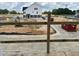 New construction site with a view of a white home with black trim, showing the developing neighborhood at 803 Fireship Rd, Fuquay Varina, NC 27526