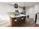 Open-concept kitchen with a central island, modern pendant lighting, and seating for four at 803 Fireship Rd, Fuquay Varina, NC 27526