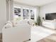Living room with large windows, white furniture, and a modern entertainment center at 803 Fireship Rd, Fuquay Varina, NC 27526