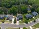 Aerial view of a brick home with manicured lawn in a neighborhood on a large lot near the pond at 817 Highwater Pl, Fuquay Varina, NC 27526