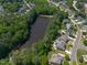 Beautiful aerial view of neighborhood with lush trees, a pond and some homes with pools at 817 Highwater Pl, Fuquay Varina, NC 27526