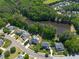 Beautiful aerial view of a neighborhood with lush trees, a pond and homes with private pools at 817 Highwater Pl, Fuquay Varina, NC 27526