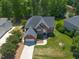 Gorgeous aerial view of a brick home with manicured lawn on a large lot with lush trees at 817 Highwater Pl, Fuquay Varina, NC 27526