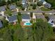Aerial view of a white home with a pool and large backyard in a neighborhood with lush trees at 817 Highwater Pl, Fuquay Varina, NC 27526