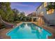 Beautiful backyard showcasing a large pool with a slide, deck, stairs, and a manicured lawn surrounded by trees at 817 Highwater Pl, Fuquay Varina, NC 27526