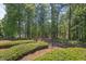 Fenced backyard with lush greenery and a gate leading to lake access at 817 Highwater Pl, Fuquay Varina, NC 27526