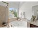 Bright bathroom features a soaking tub, separate shower, and view to the outside at 817 Highwater Pl, Fuquay Varina, NC 27526