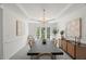 Bright dining room features a modern chandelier, neutral walls, and buffet with decorative accents at 817 Highwater Pl, Fuquay Varina, NC 27526