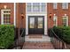 Elegant double front doors framed by sconces and a 'Welcome' mat, leading to a beautiful brick home at 817 Highwater Pl, Fuquay Varina, NC 27526