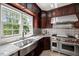 A gourmet kitchen featuring stainless steel appliances, granite countertops, and a farmhouse sink at 817 Highwater Pl, Fuquay Varina, NC 27526