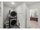 Convenient laundry room with washer, dryer, and a peek into the bathroom with wooden vanity at 817 Highwater Pl, Fuquay Varina, NC 27526