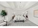 Bright main bedroom features neutral decor, trey ceilings and modern chandelier lighting at 817 Highwater Pl, Fuquay Varina, NC 27526