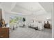 Airy main bedroom features ample natural light, sitting area, and trey ceiling with modern chandelier at 817 Highwater Pl, Fuquay Varina, NC 27526
