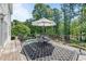 Spacious deck features a table set and shade umbrella, beside a pool and lush backyard at 817 Highwater Pl, Fuquay Varina, NC 27526