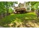 View of the backyard featuring a lush lawn, wooden deck, and privacy fence at 8600 Clivedon Dr, Raleigh, NC 27615
