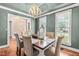Dining room with six chairs, lantern centerpieces, two windows, and an ornamental chandelier at 8600 Clivedon Dr, Raleigh, NC 27615