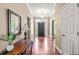 Open foyer with wood flooring, elegant table with lamp and mirror, offering a warm welcome at 8600 Clivedon Dr, Raleigh, NC 27615