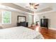 Spacious main bedroom with hardwood floors, tray ceilings, ceiling fan, and ensuite bathroom at 8600 Clivedon Dr, Raleigh, NC 27615