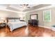 Relaxing main bedroom with a tray ceiling, ceiling fan, and wood floors at 8600 Clivedon Dr, Raleigh, NC 27615