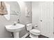Stylish powder room with pedestal sink, decorative mirror, and modern fixtures at 8600 Clivedon Dr, Raleigh, NC 27615
