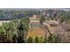 This aerial shows the house, its surrounding wooded landscape, and its placement alongside a quiet street at 900 Roxboro Road, Oxford, NC 27565