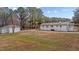 A wide-open green backyard leads to a white home and garage at 900 Roxboro Road, Oxford, NC 27565